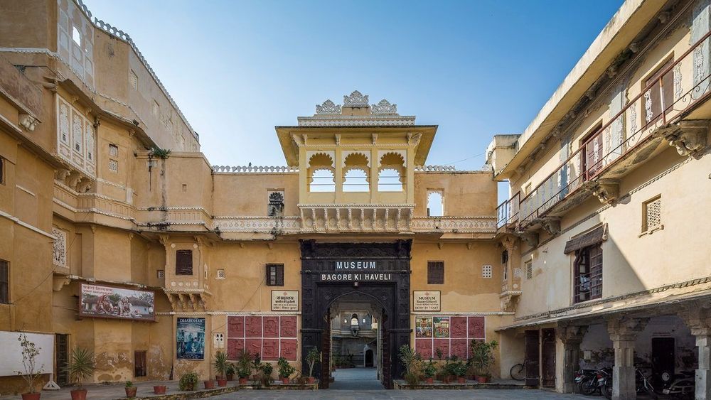 Visitors entering the decorated gateway of Bagore Ki Haveli Museum in Udaipur